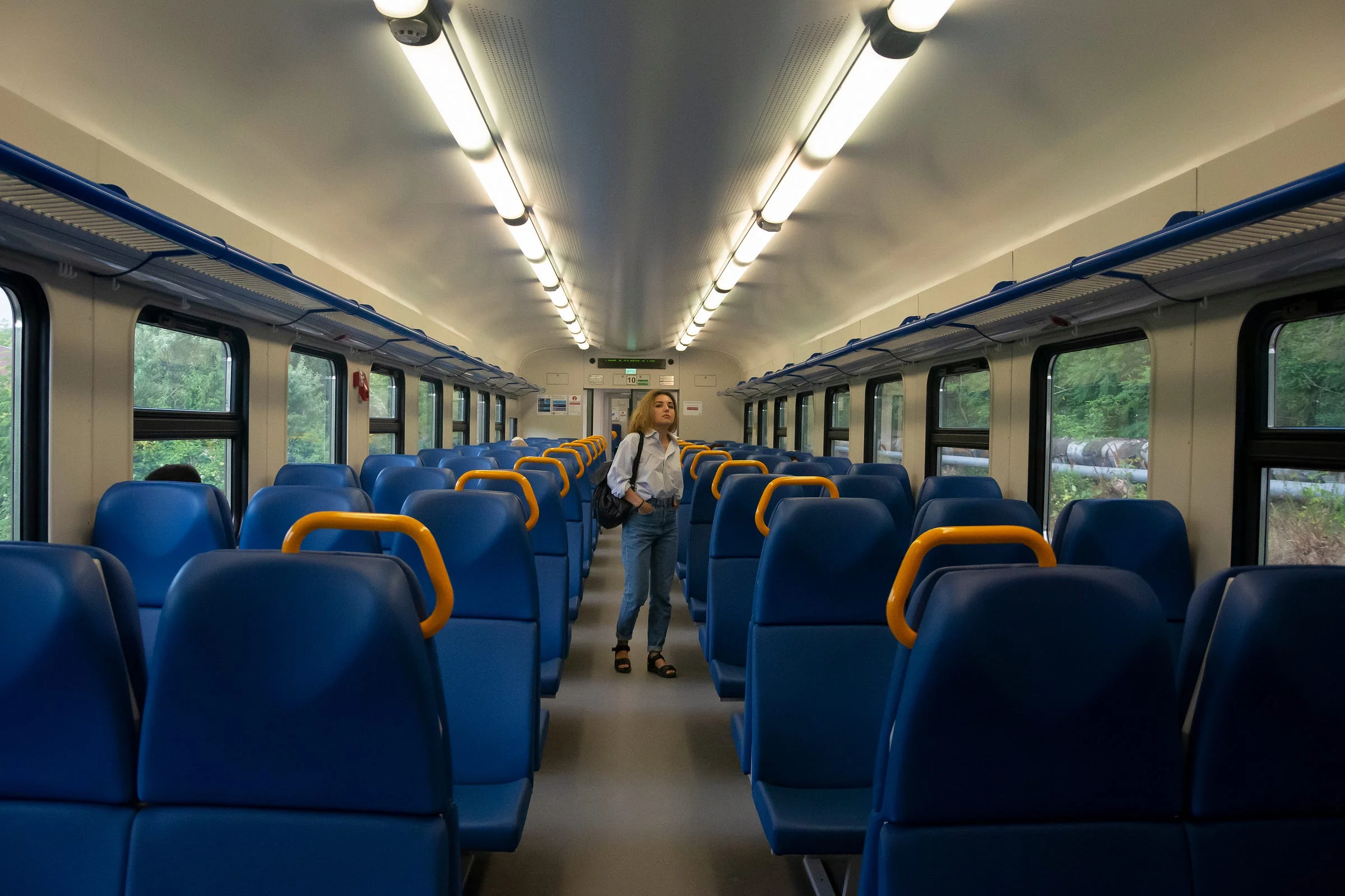 Train interior with seats and aisle, the kind of detail shot that places the viewer on board